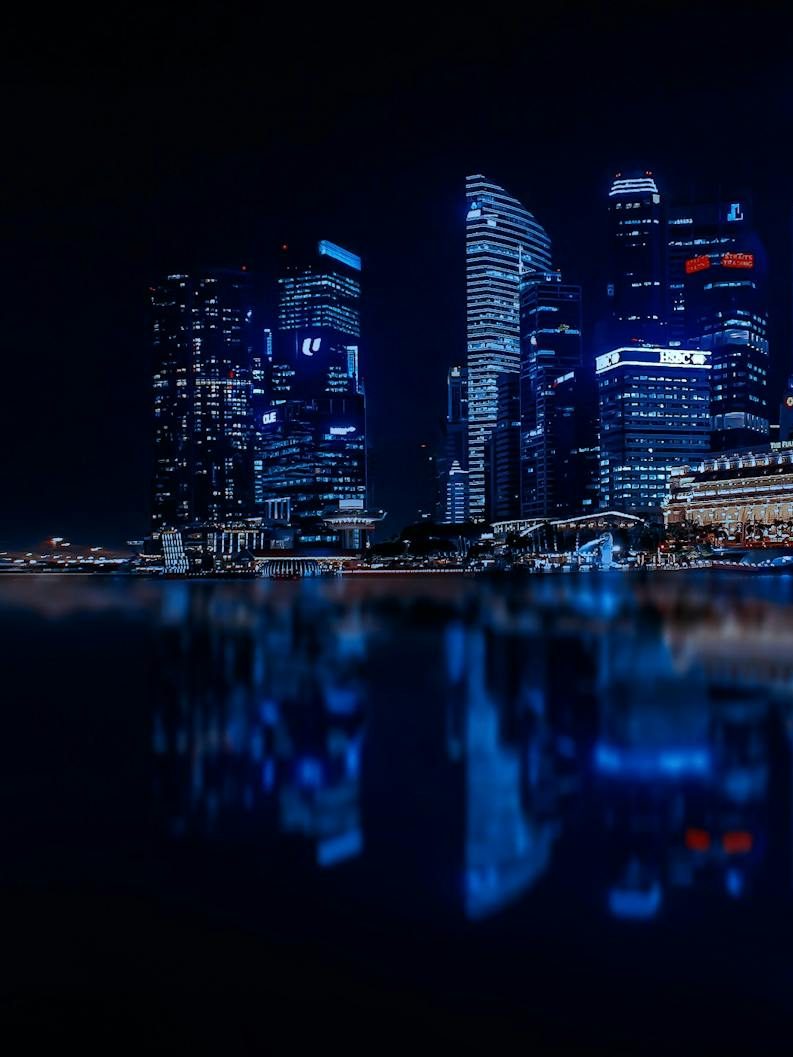 illuminated cityscape against blue sky at night
